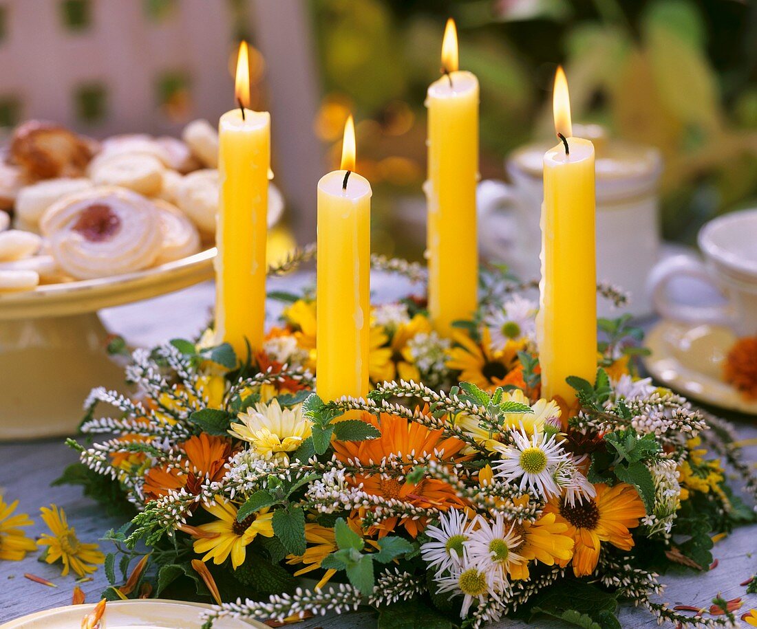 Tischkranz mit Herbstblüten und Kerzen