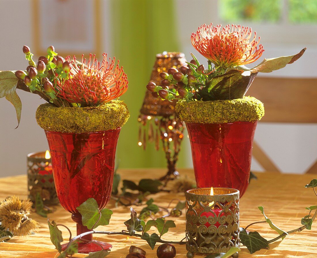 Wine glasses with moss wreaths, Protea flowers & Hypericum 