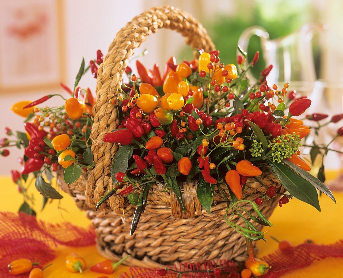 Arrangement of ornamental peppers and rose hips in basket