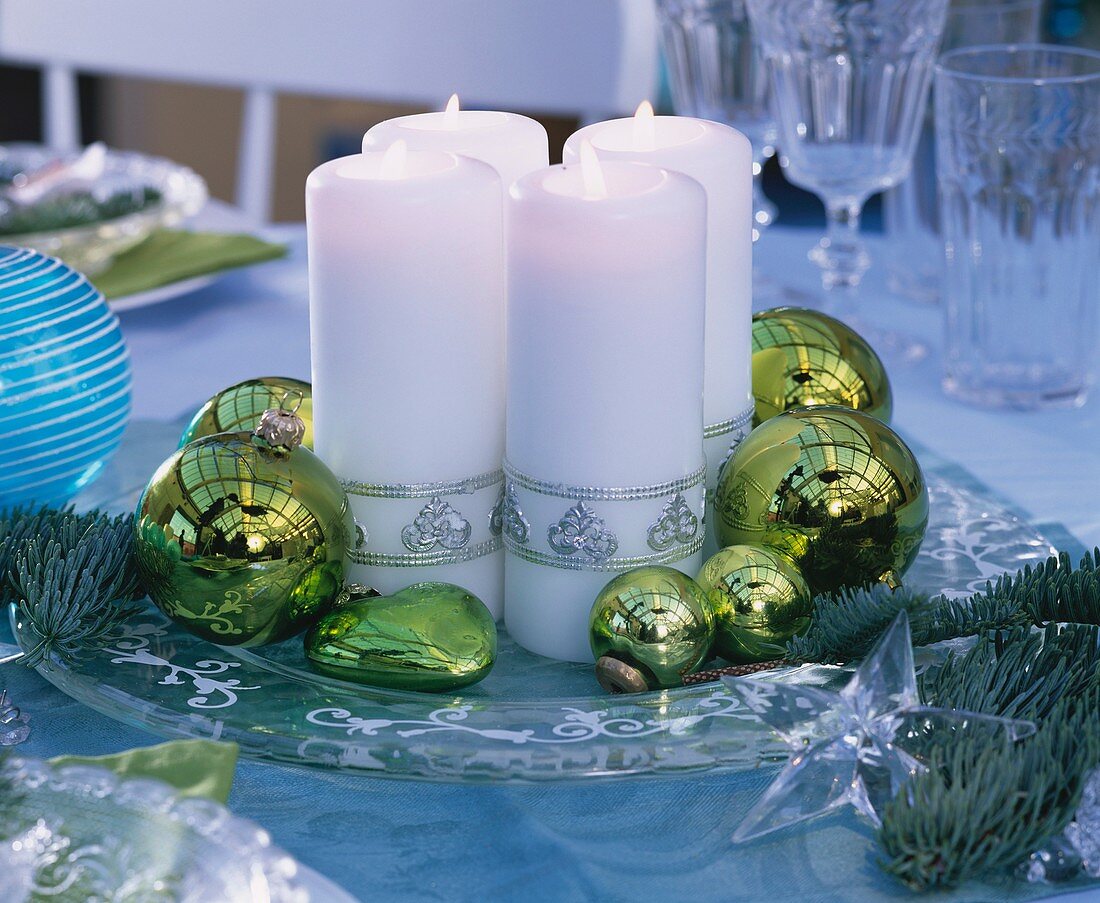Glasteller mit weissen Kerzen und Christbaumkugeln