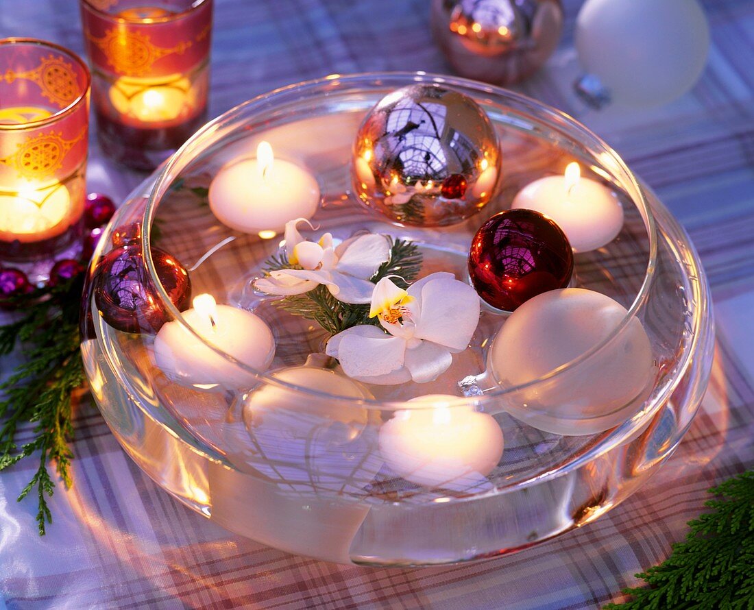 Floating candles and baubles with orchids