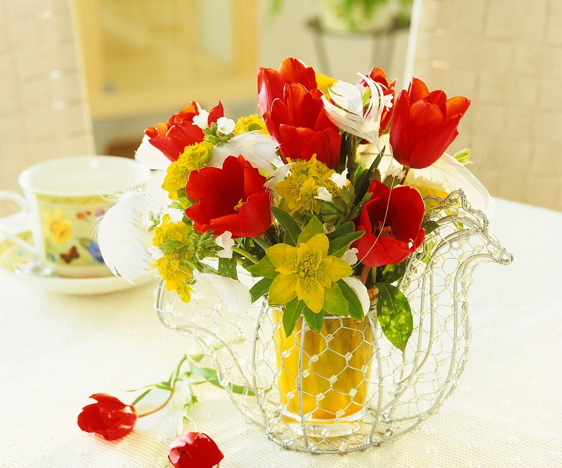 Drahthenne als Vase mit Tulpen und Wolfsmilch