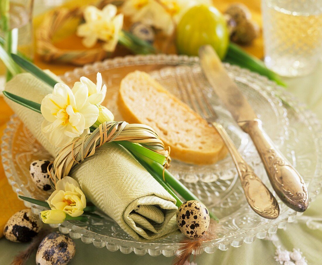 Place setting with narcissi, quail's eggs and slice of bread