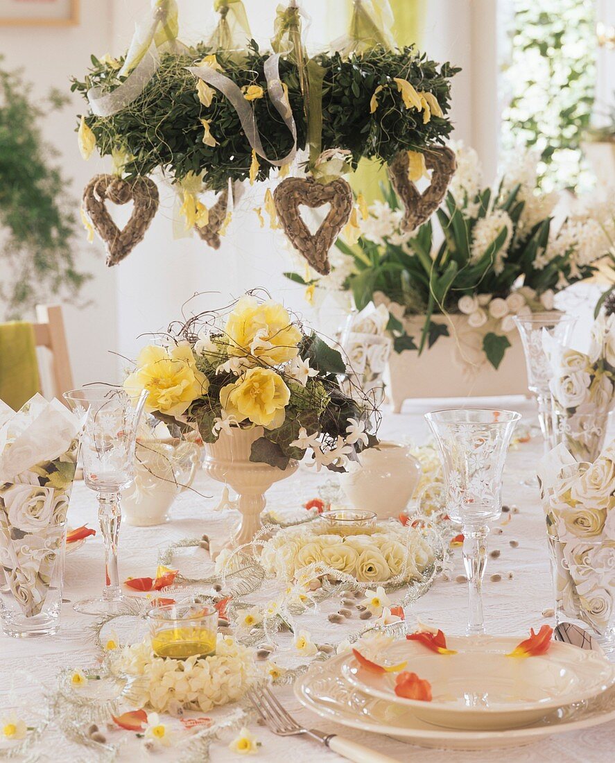 Festlich gedeckter Tisch mit Blumen und Deckenkranz