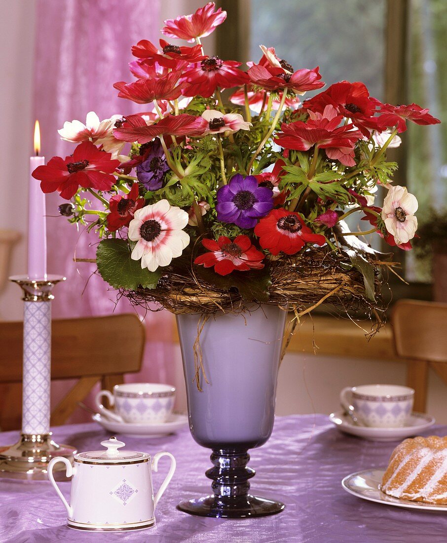 Tisch mit Kronenanemonen, Tassen und Mini-Gugelhupf