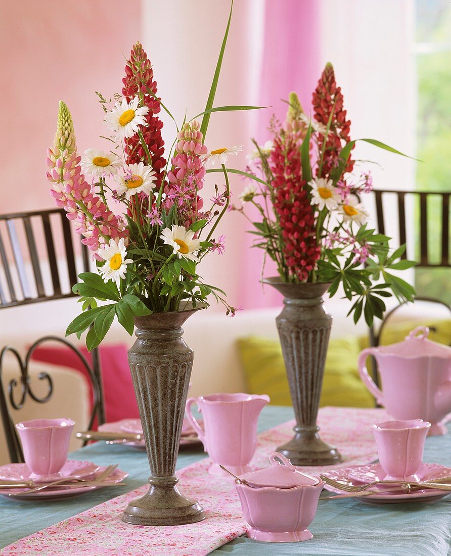 Pink crockery & arrangement of lupins, marguerites, ragged robin