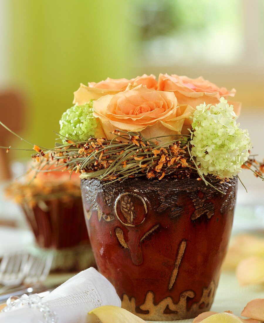 Salmon roses with Viburnum and wreath of broom