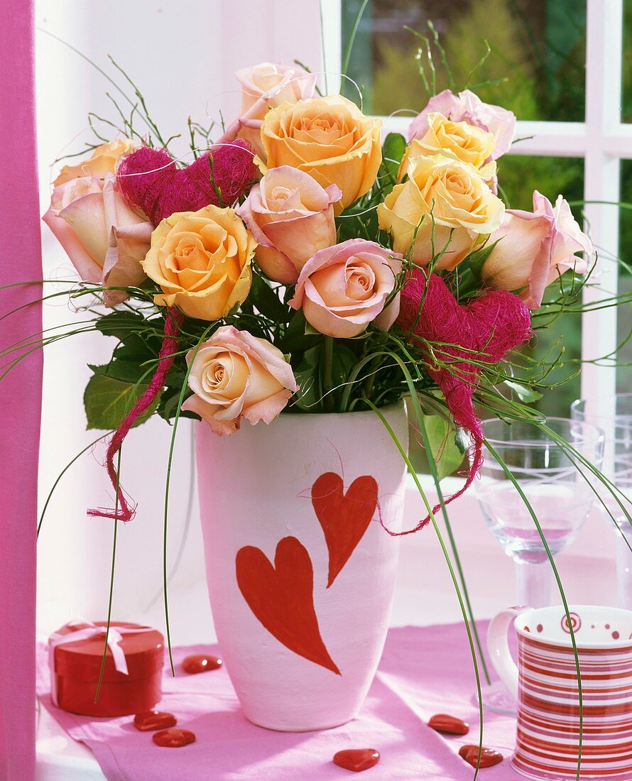 Vase of roses with red sisal hearts