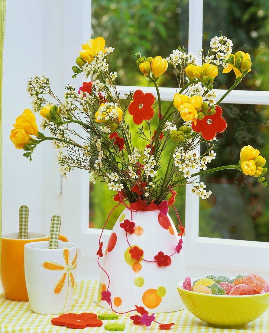 Arrangement of freesias and Hoya, bowl of sweets