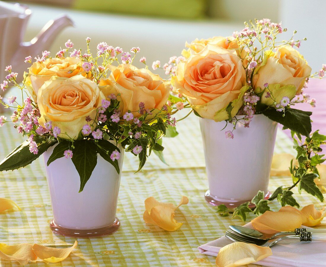 Rosen mit Schleierkraut und Efeu in rosa Vasen