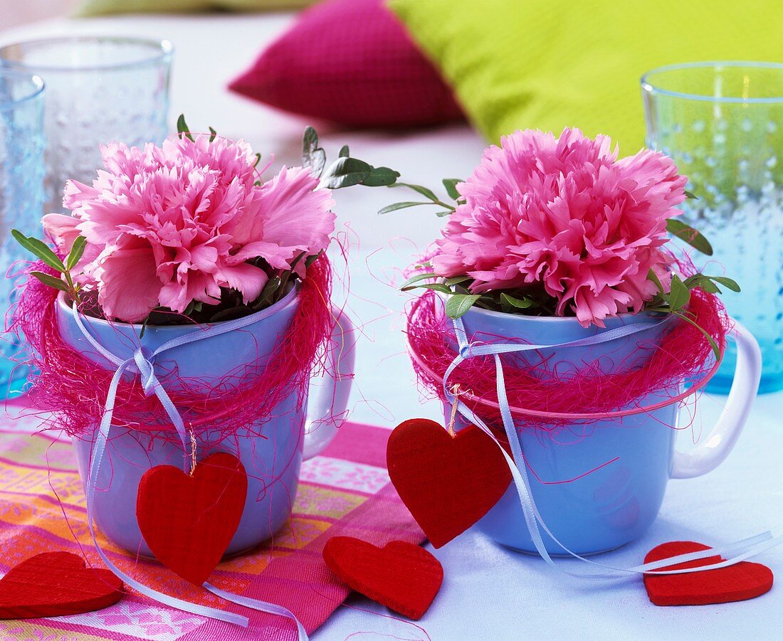 Carnations in blue cups decorated with sisal and hearts