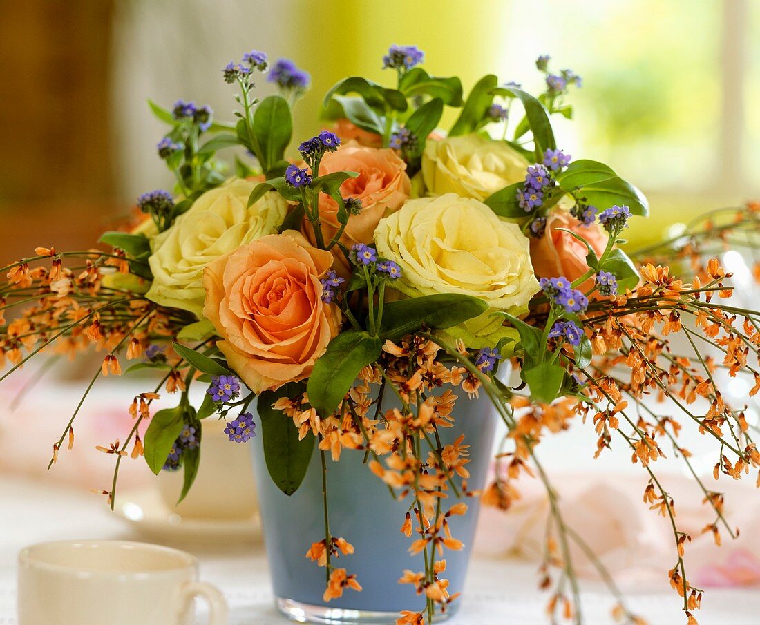 Vase of roses with forget-me-nots and broom
