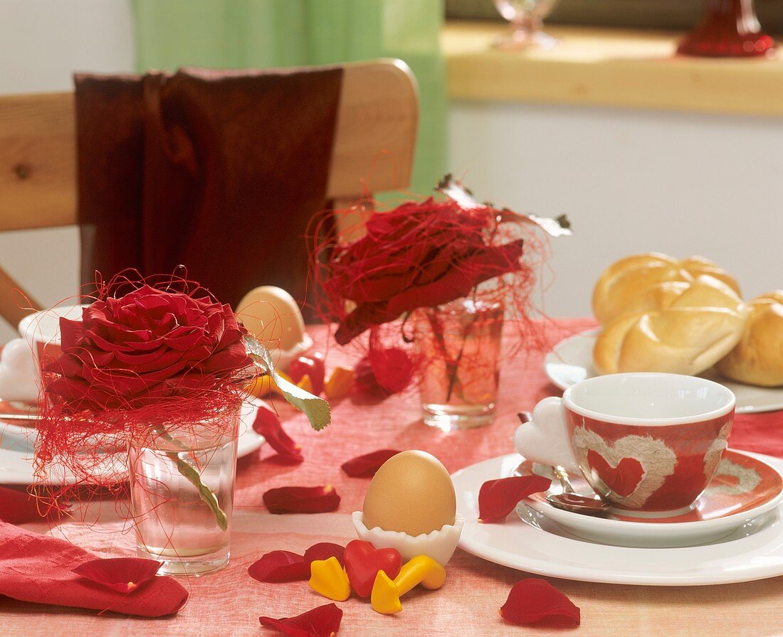 Frühstückstisch mit roten Rosenblüten und Sisal dekoriert