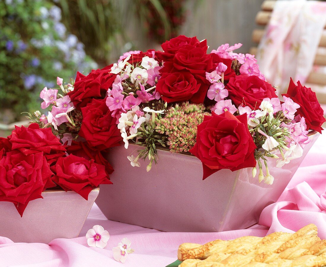Jardiniere mit roten Rosen und Flammenblumen