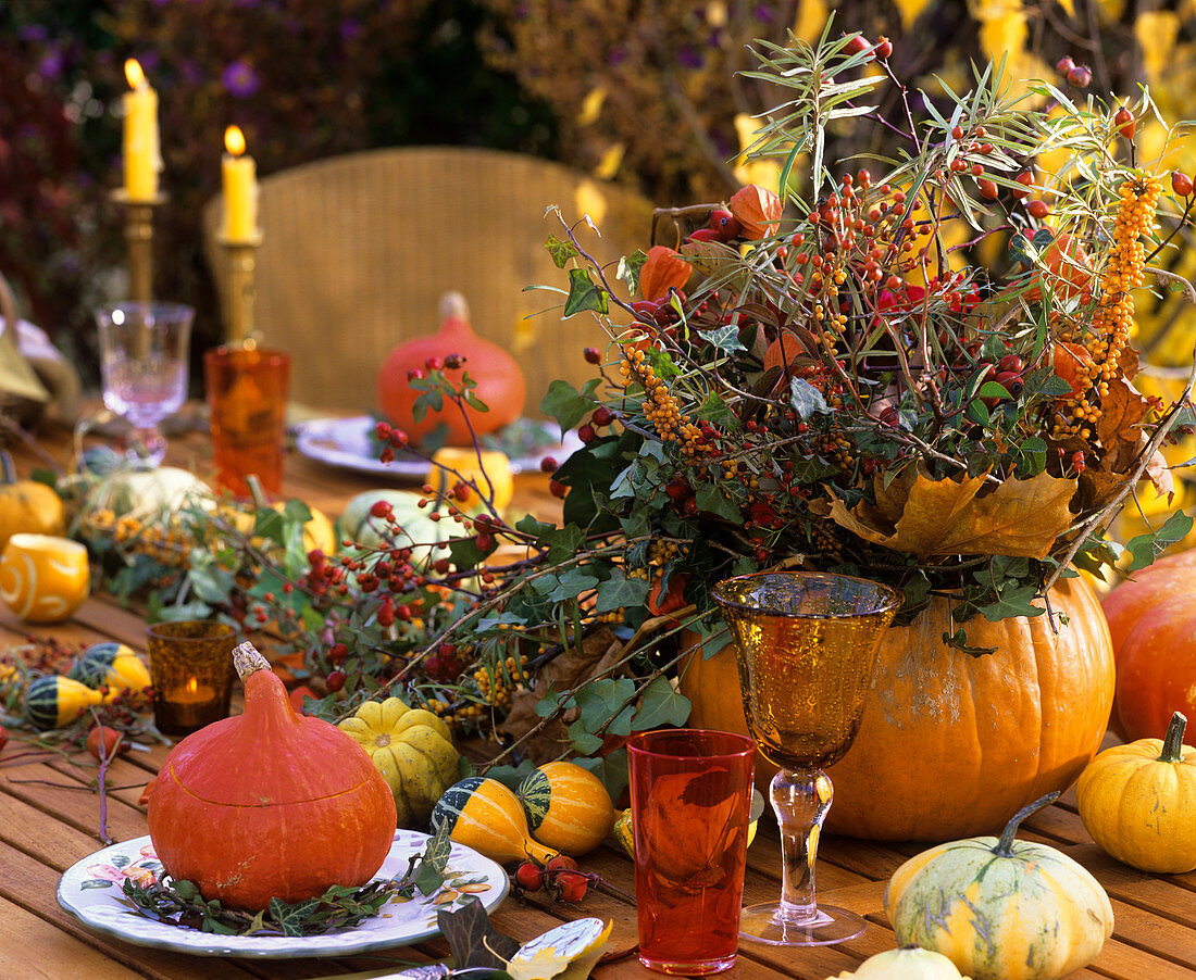 Herbstliches Blumengesteck und Zierkürbisse auf dem Tisch