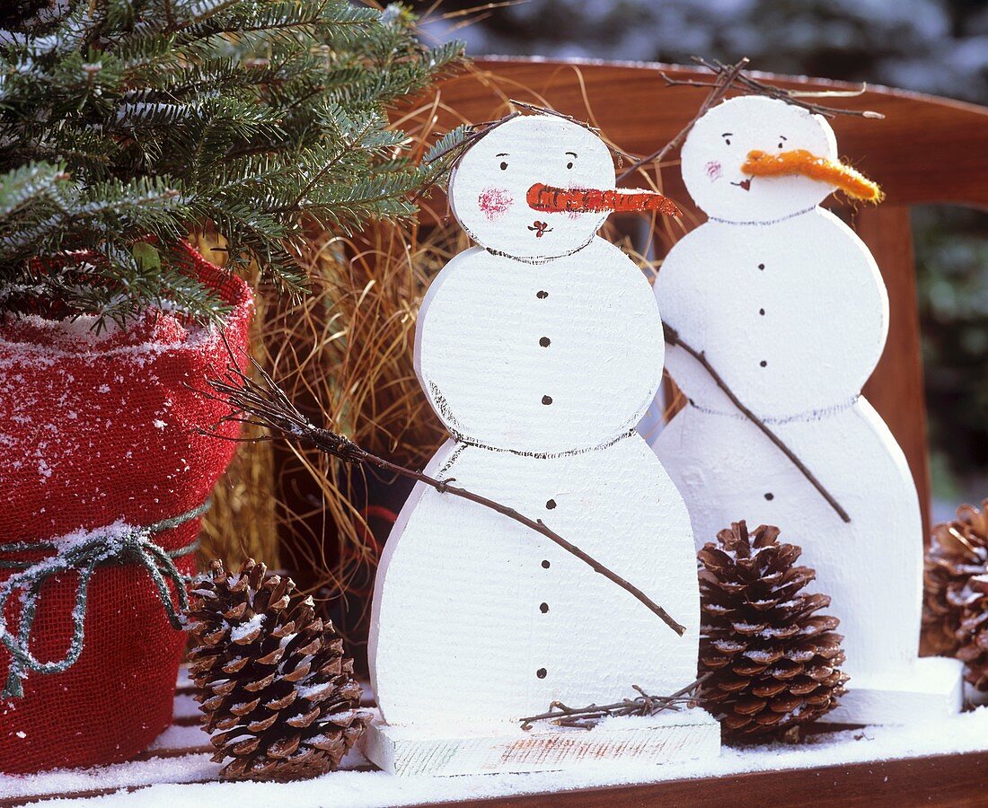 Wooden snowmen on a garden bench