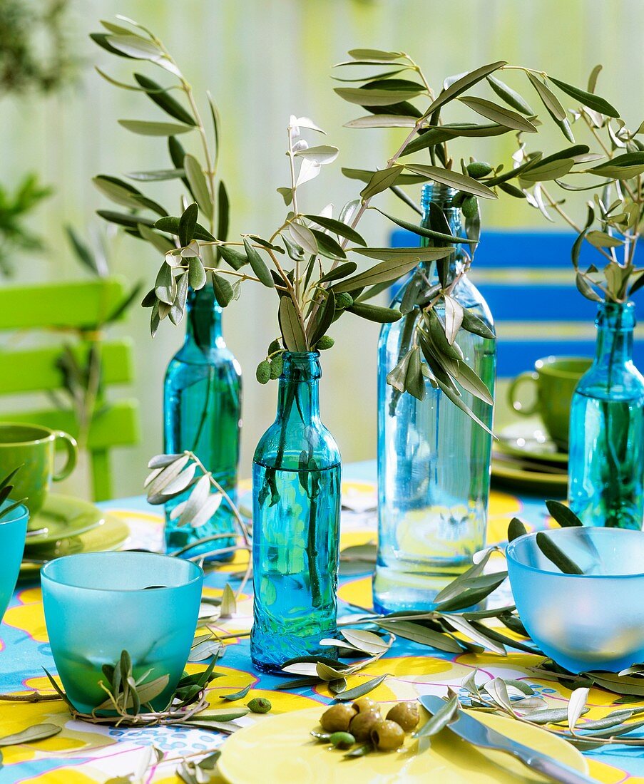 Olivenzweige in Flaschen als Tischdeko