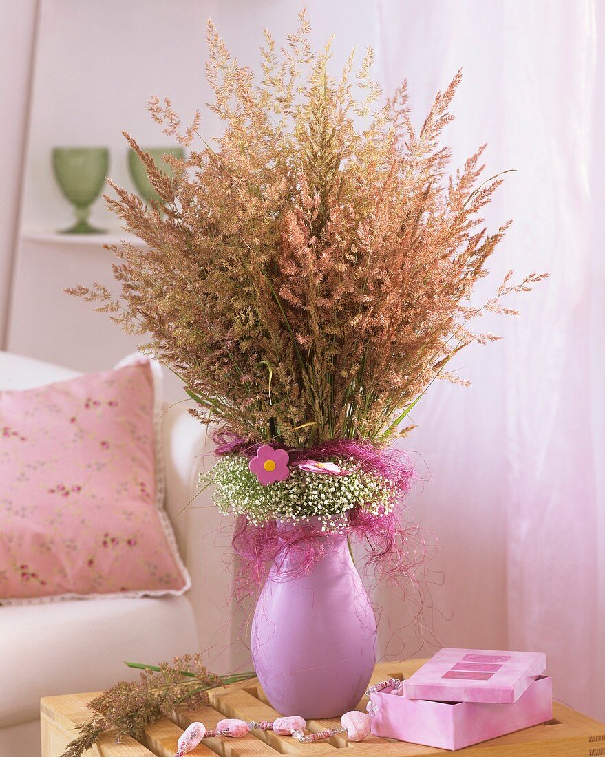 Vase of meadow grasses, frill of Gypsophila and sisal