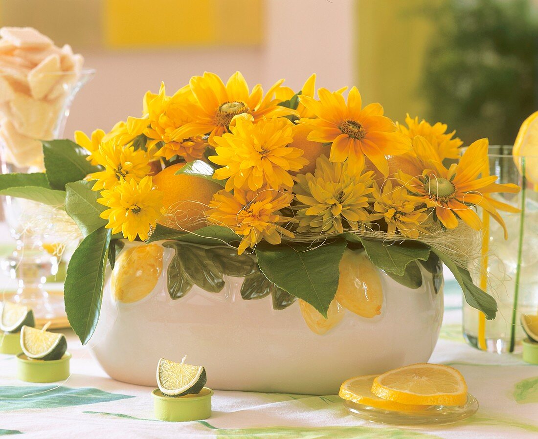 Schale mit Dahlienblüten und Zitronen