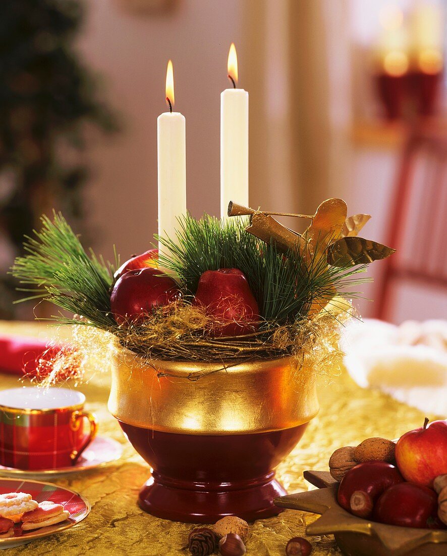 Adventsgesteck mit Äpfeln, Zweigen und Kerzen
