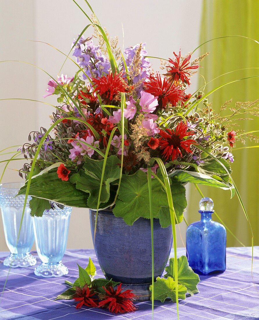 Sommerlicher Blumenstrauss mit Gräsern in blauer Vase
