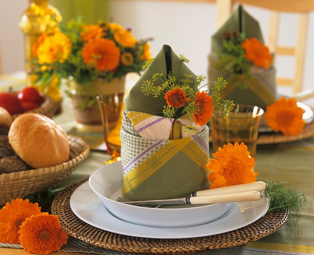 Summery napkin decoration of marigolds and dill flowers