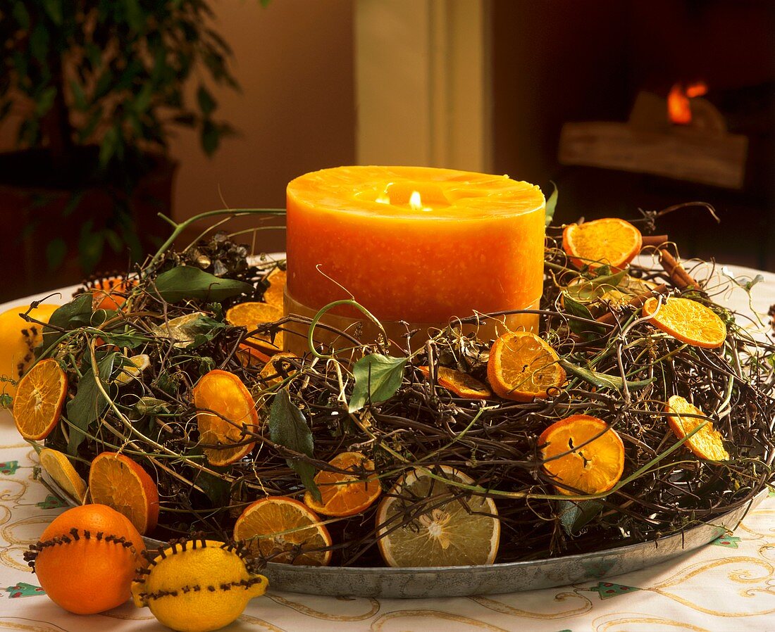 Adventskranz mit Zitrusfrüchten und orangefarbener Kerze