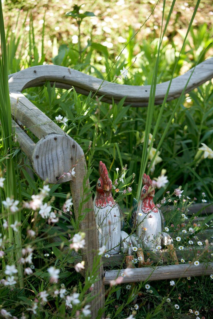 Hühnerfiguren auf Gartenbank