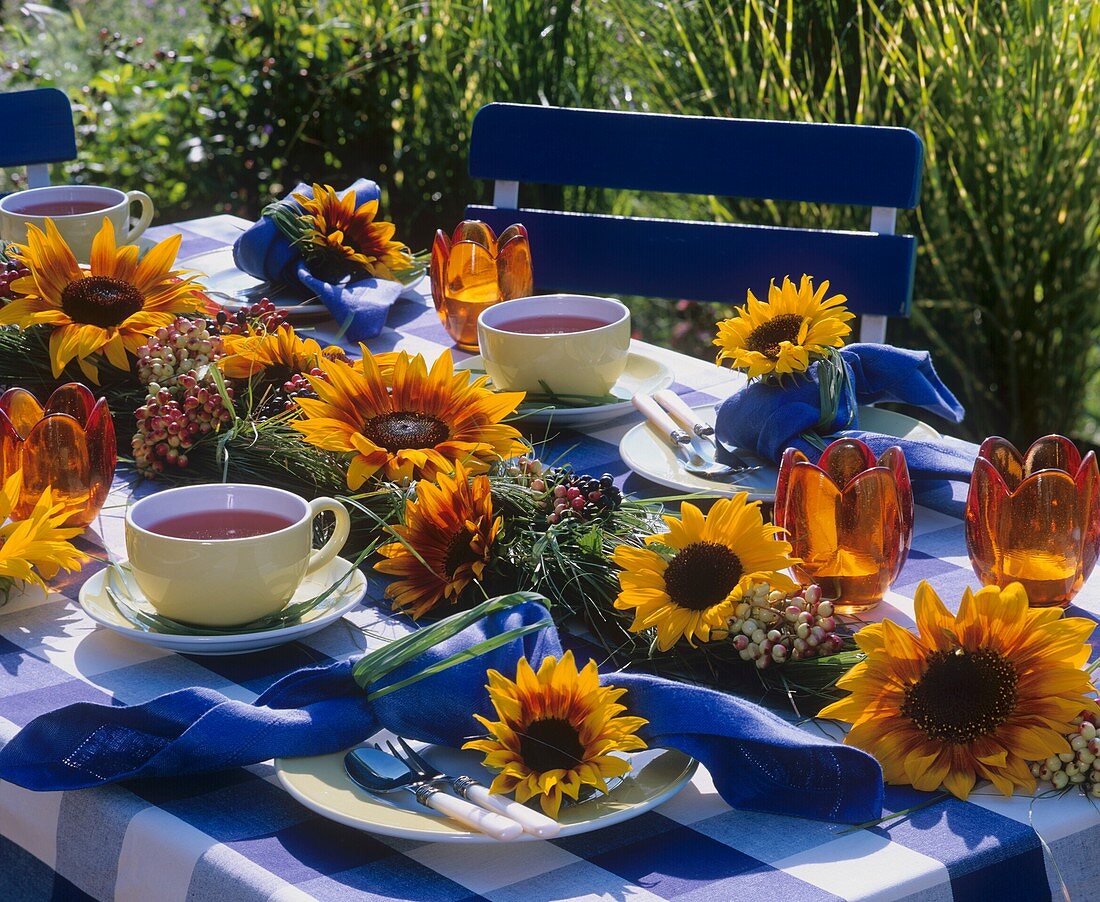 Gartentisch mit Sonnenblumengirlande und Teegedeck
