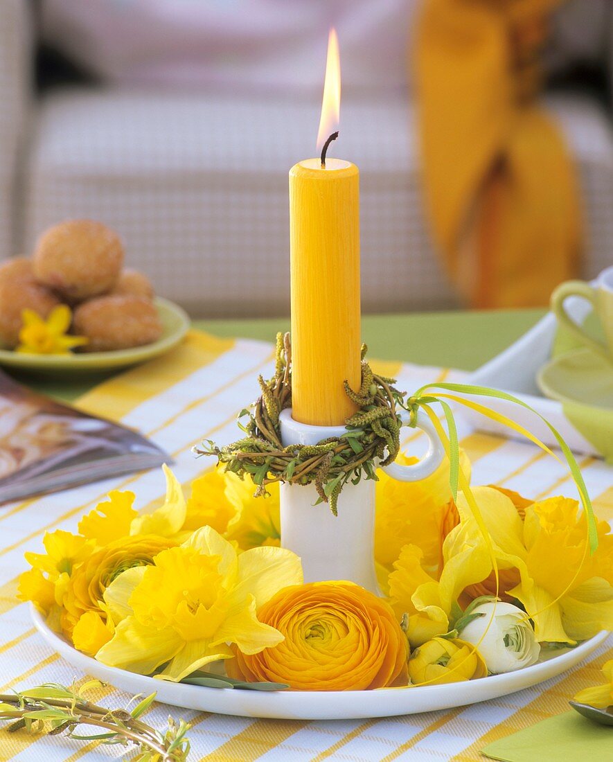 Candlestick with candle, willow wreath, narcissi, ranunculus