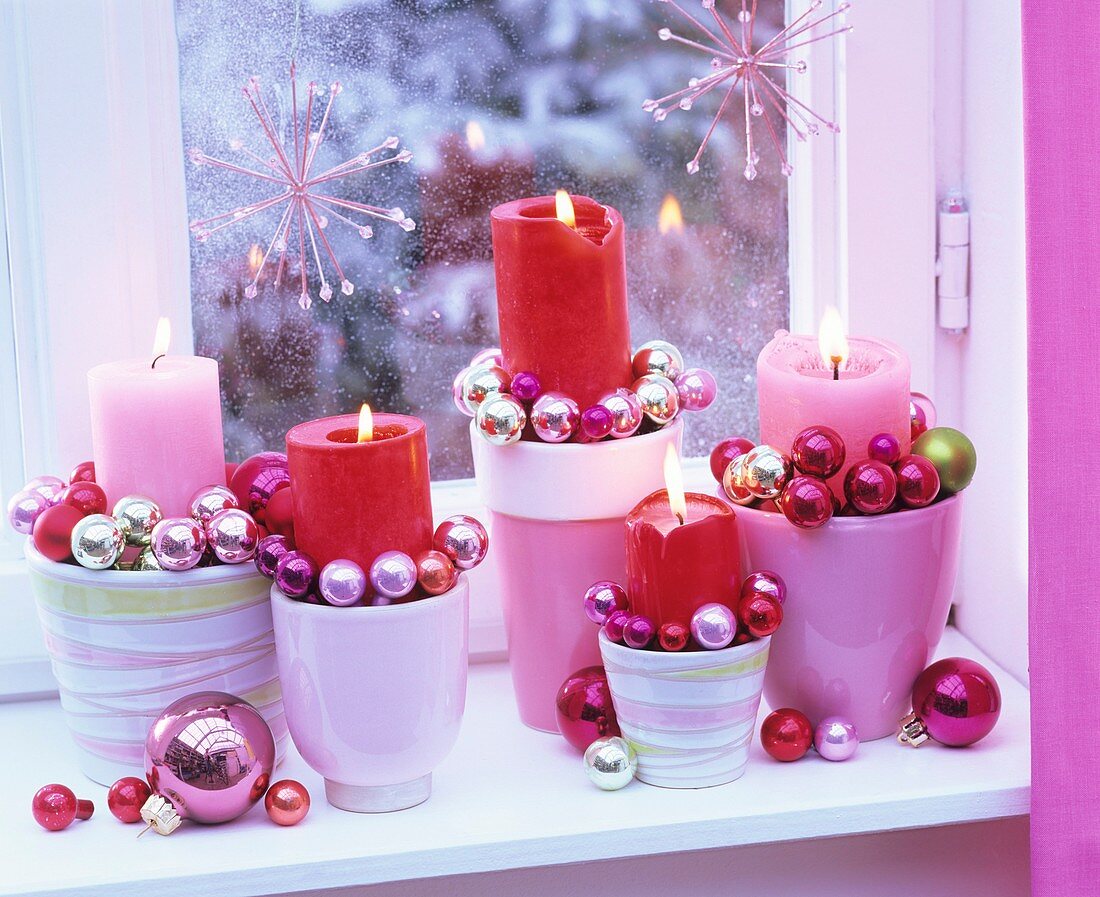 Advent arrangement of candles and small baubles by window