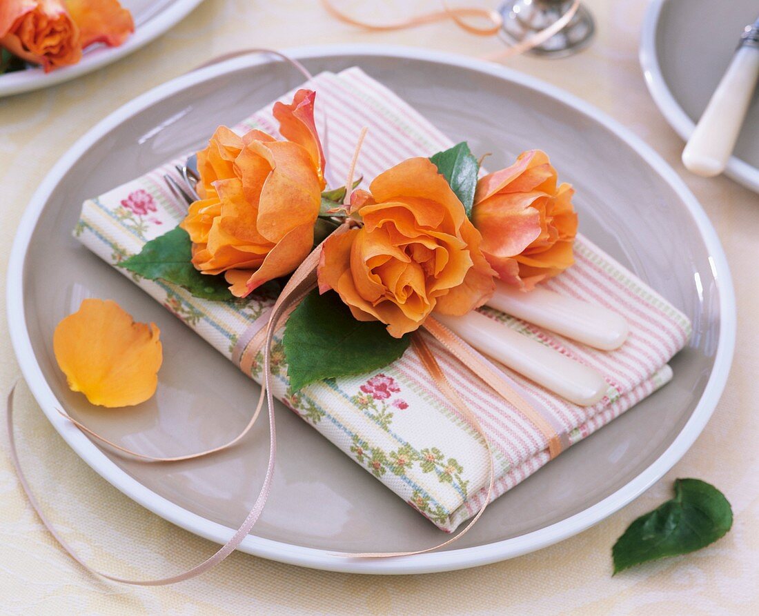 Napkin decoration of orange roses