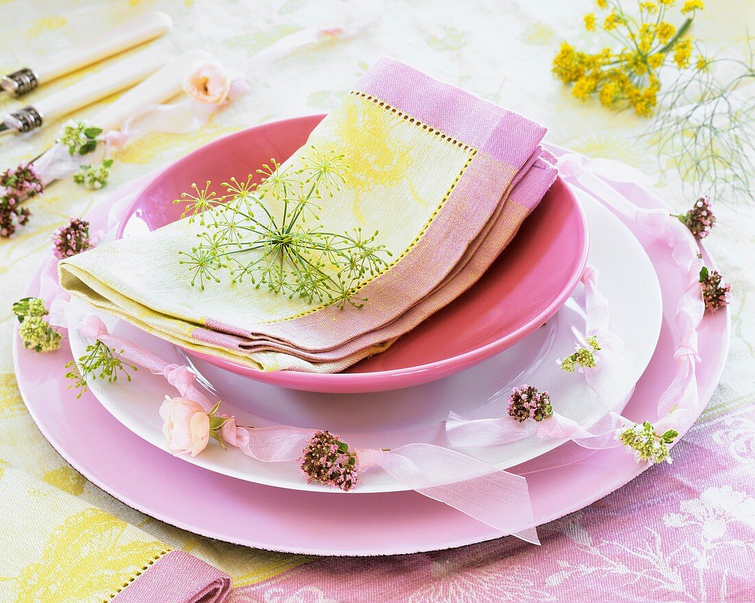 Place-setting in shades of pink with flowering herbs & napkin