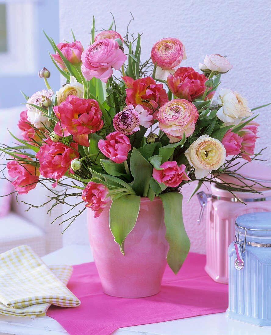 Vase of pink tulips, ranunculus, bilberry twigs