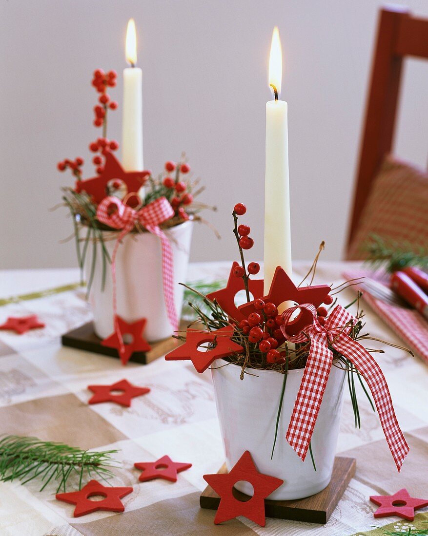Arrangements of ilex berries, pine, red stars and candles