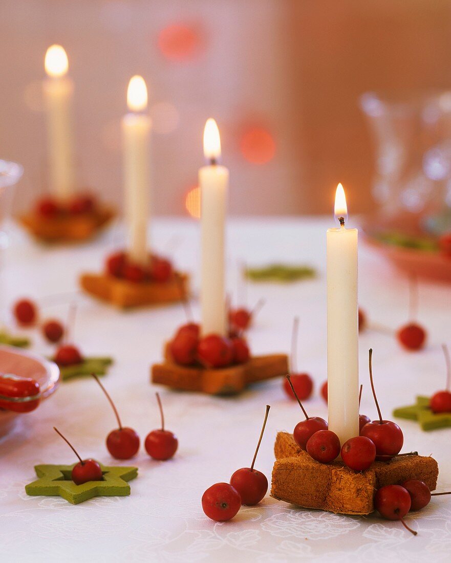 Star-shaped candle holders with crab apples & white candles