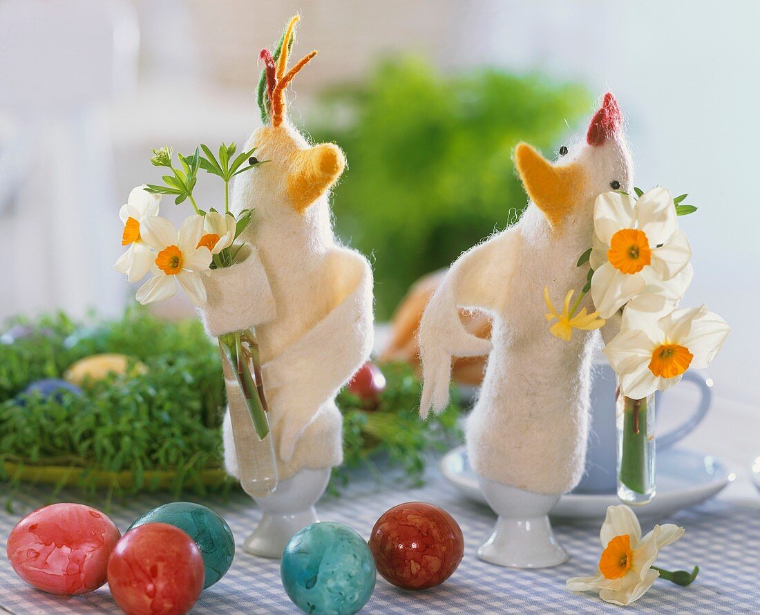 Felt chicken egg cosies with small posies of narcissi