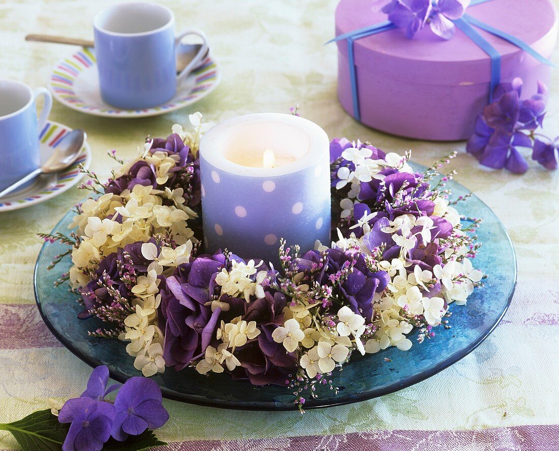 Wreath of hydrangeas and sea lavender around blue candle