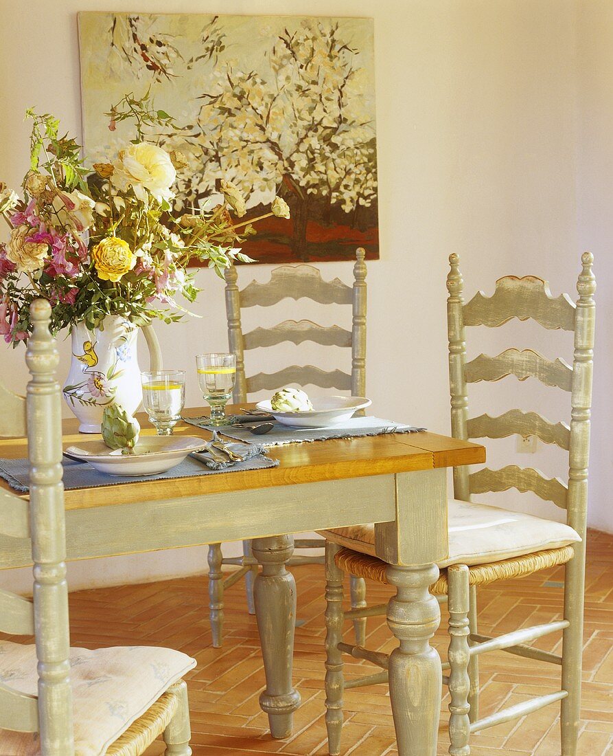 Gedeckter Tisch mit Blumenstrauss und Artischocken