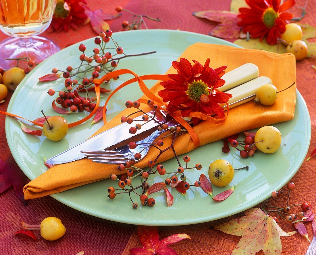 Gedeck mit Hagebutten und Herbstchrysanthemen dekoriert