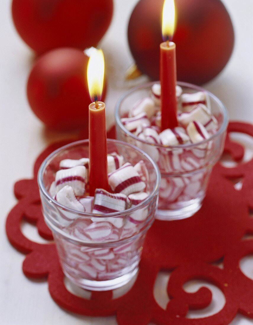 Kerzen in Gläsern mit weiss-roten Bonbons