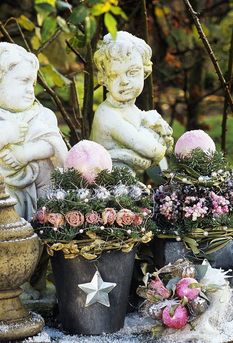 Romantische Topfgestecke und Steinfiguren als Gartendeko