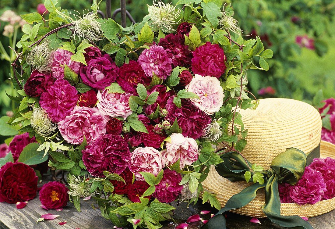 Heart-shaped arrangement of roses and straw hat