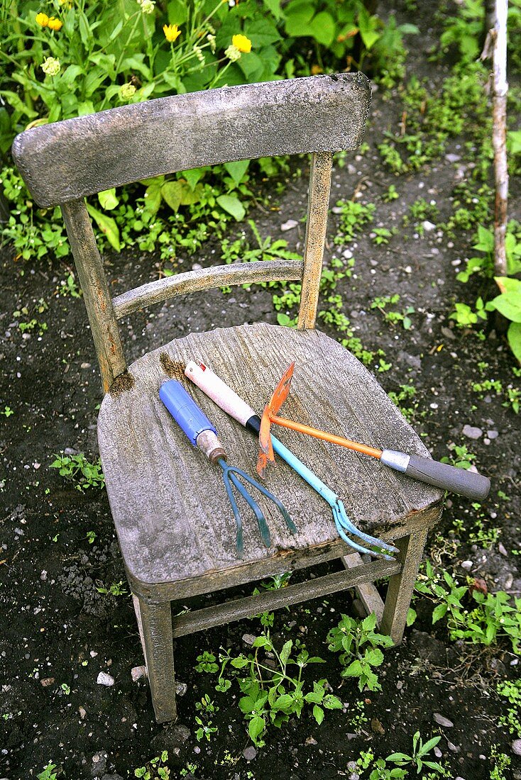 Gartenwerkzeug auf altem Holzstuhl