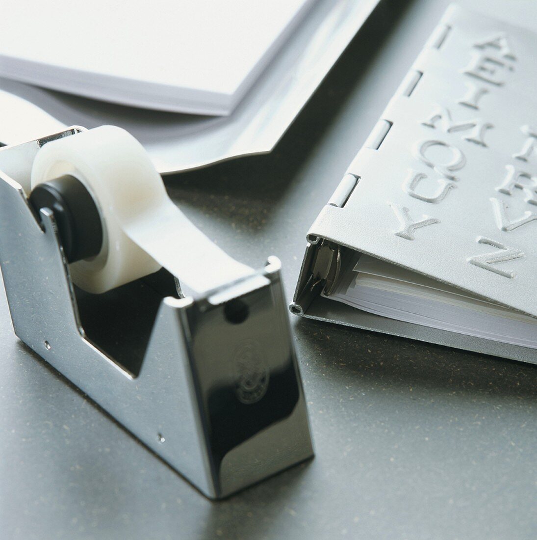 Büroutensilien aus Metall - Tesafilmhalter und Ordner mit aufgeprägten Zierbuchstaben