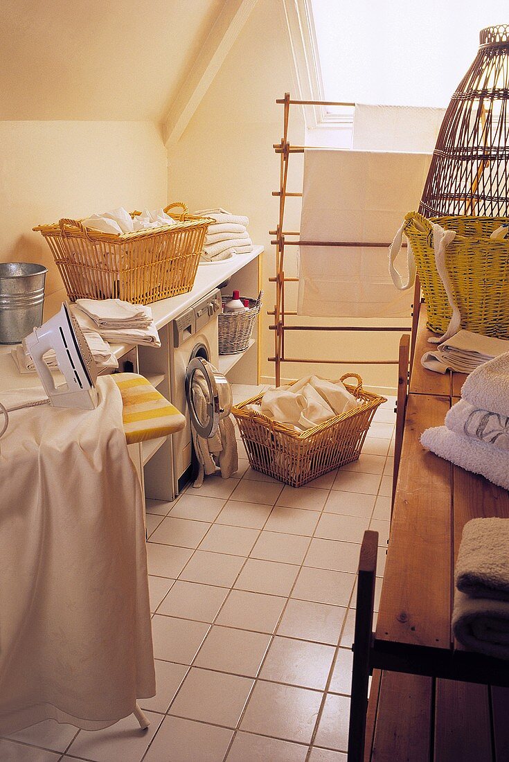 Attic laundry room with baskets of washing and an iron