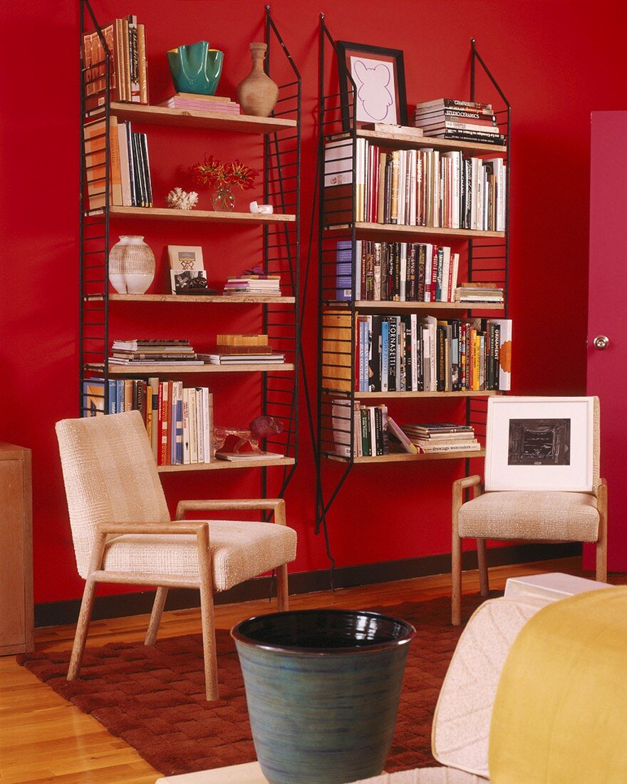 Interior with 70s shelves mounted on bright red walls and 50-style chairs