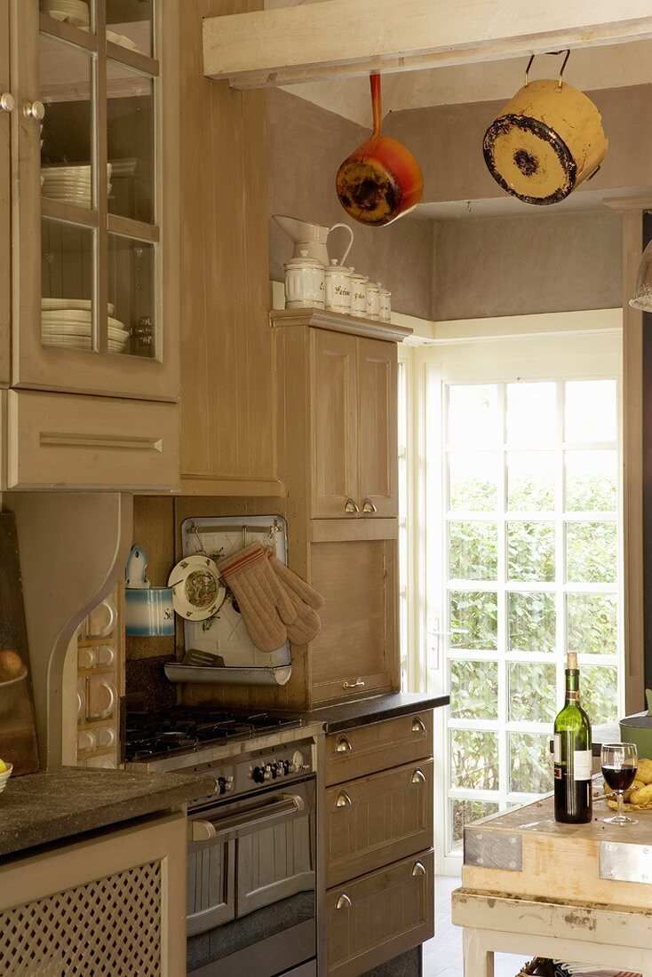 Detail of fitted, country-house-style kitchen with view of garden through lattice window