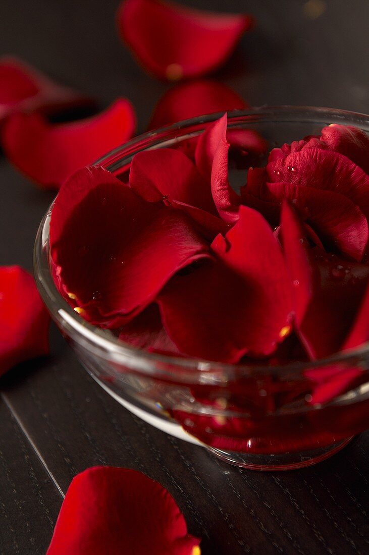 Rote Rosenblütenblätter in Glasschale