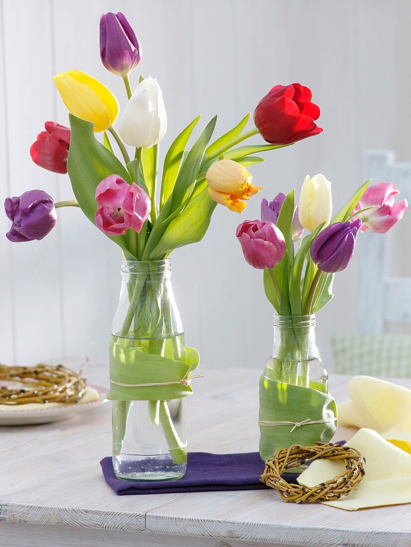 Tulips in glass bottles, small wreath of weeping willow
